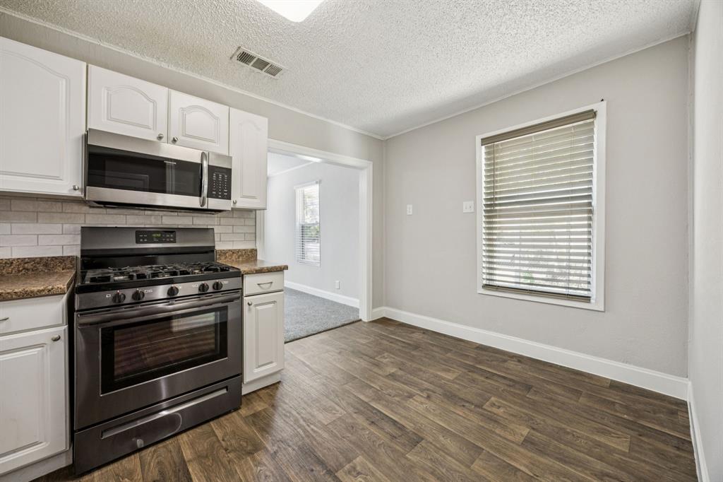 5621 Bonnie Drive Watauga, TX 76148 - Photo 10 of 40 a kitchen with stainless steel appliances a stove a microwave and cabinets