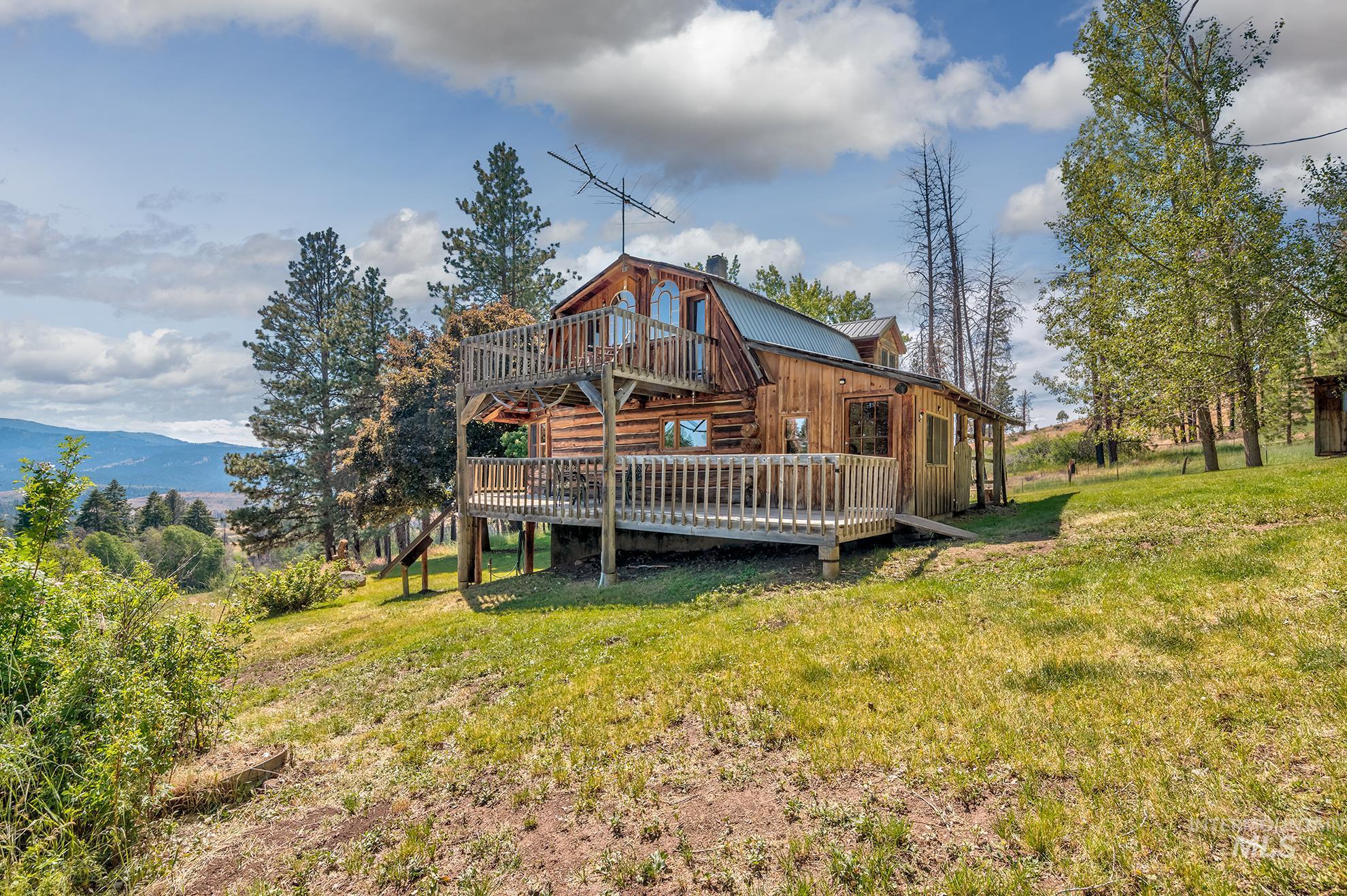 2150 Seid Creek Road Cambridge, ID 83610 - Photo 3 of 50 Rustic log cabin exterior featuring a multi-level wood deck and balcony