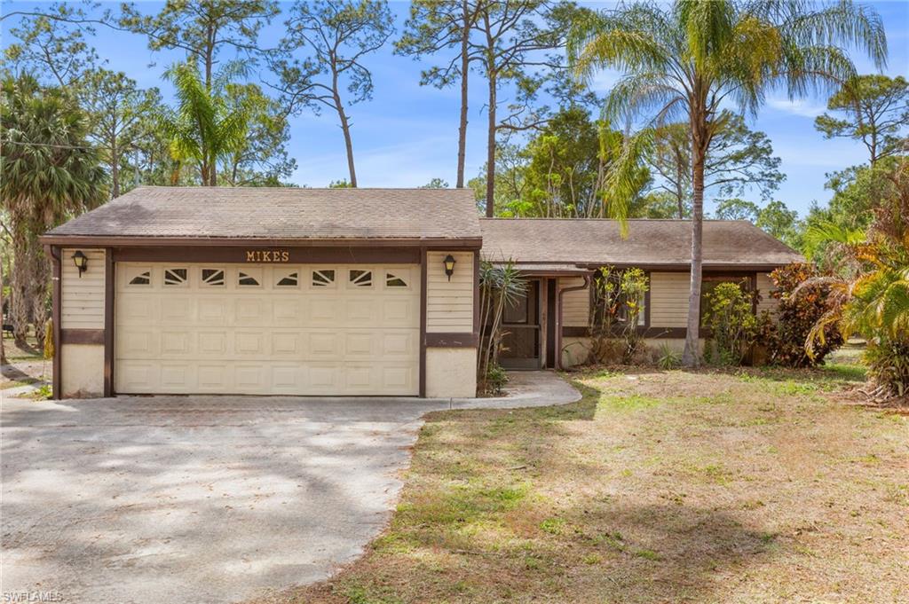 465 5th Street Southwest Naples, FL 34117 - Photo 2 of 33 Ranch-style home with driveway, a shingled roof, a front lawn, and an attached garage