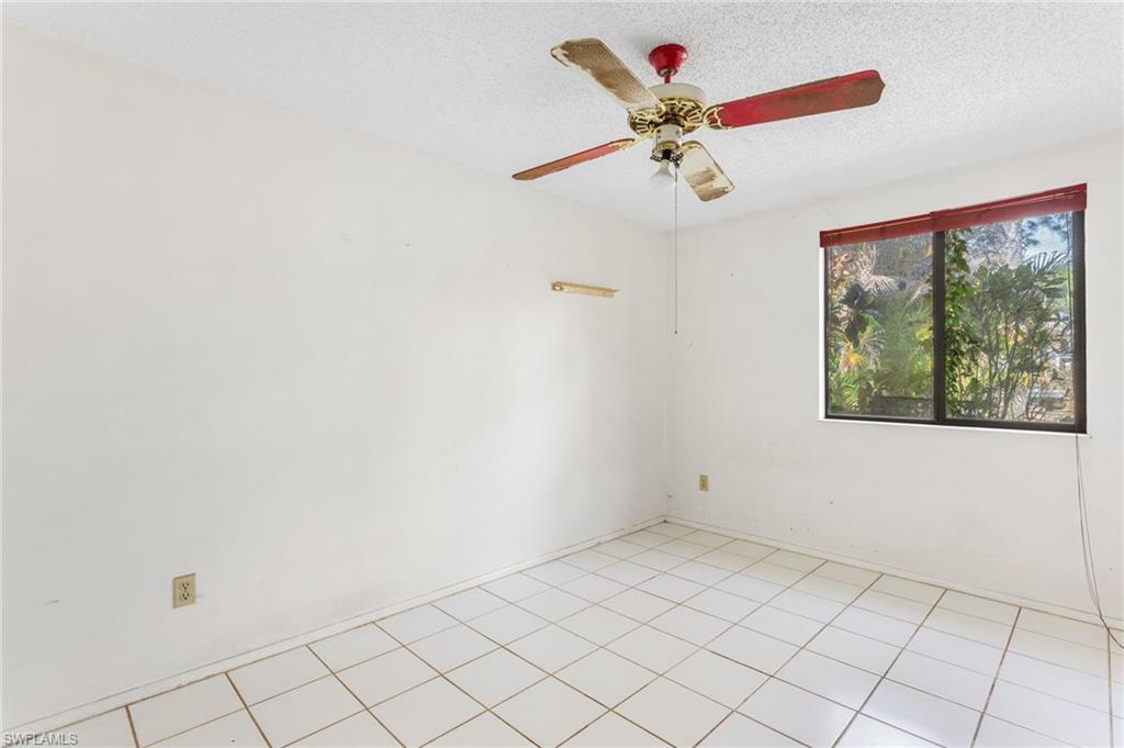 465 5th Street Southwest Naples, FL 34117 - Photo 21 of 33 Spare room featuring a textured ceiling, a ceiling fan, and light tile patterned flooring