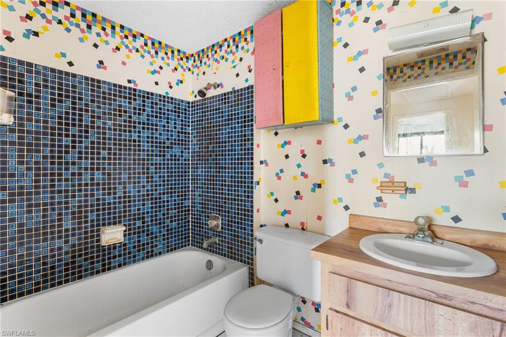 465 5th Street Southwest Naples, FL 34117 - Photo 23 of 33 Full bath with wallpapered walls, vanity, and shower combination
