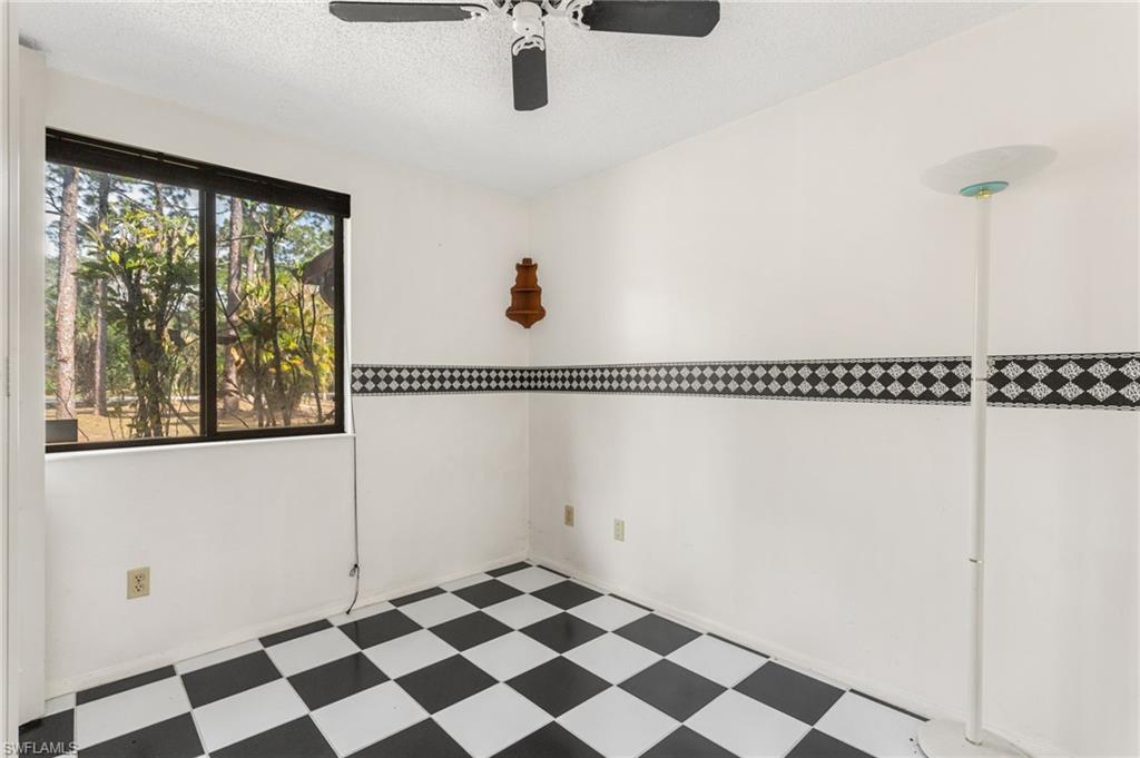 465 5th Street Southwest Naples, FL 34117 - Photo 24 of 33 Spare room with tile patterned floors, a textured ceiling, and ceiling fan
