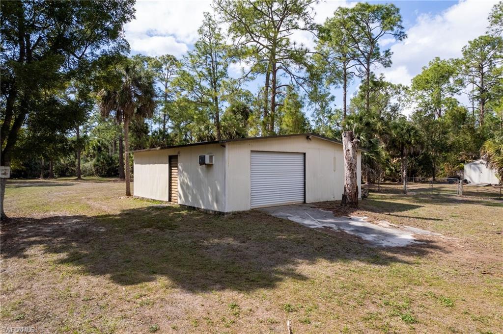 465 5th Street Southwest Naples, FL 34117 - Photo 9 of 33 Detached garage featuring view of wooded area