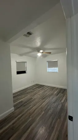 a view of empty room with wooden floor