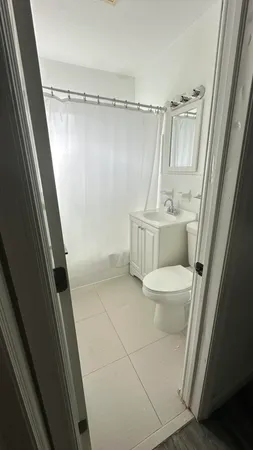 a bathroom with a sink a toilet a shower and vanity