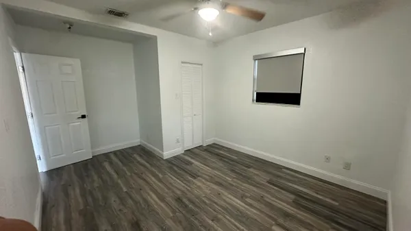 a view of an empty room with wooden floor