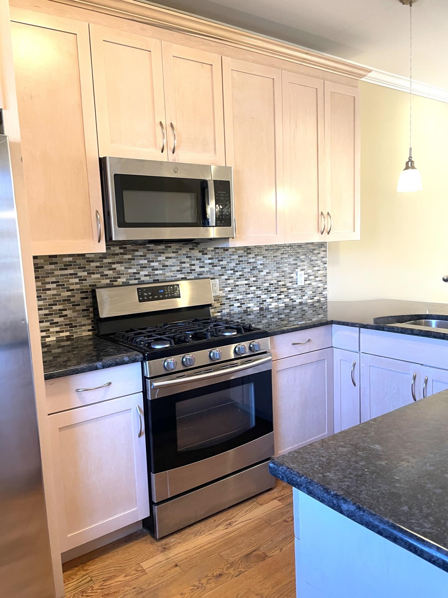 734 County Avenue, Unit B2 Secaucus, NJ 07094 - Photo 6 of 19 a kitchen with stainless steel appliances granite countertop a stove microwave and sink