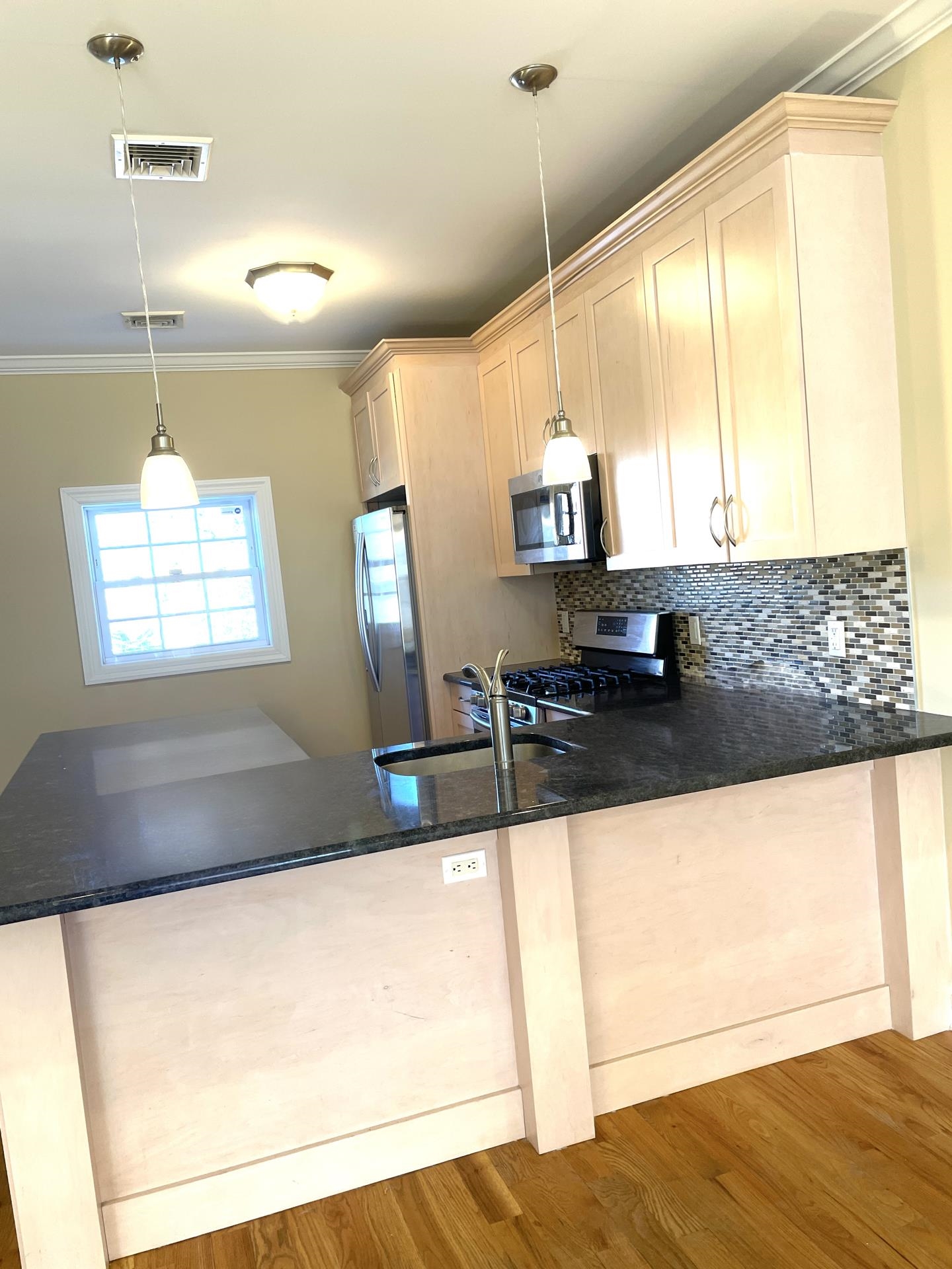 734 County Avenue, Unit B2 Secaucus, NJ 07094 - Photo 7 of 19 a kitchen with kitchen island a sink wooden floor and a large window