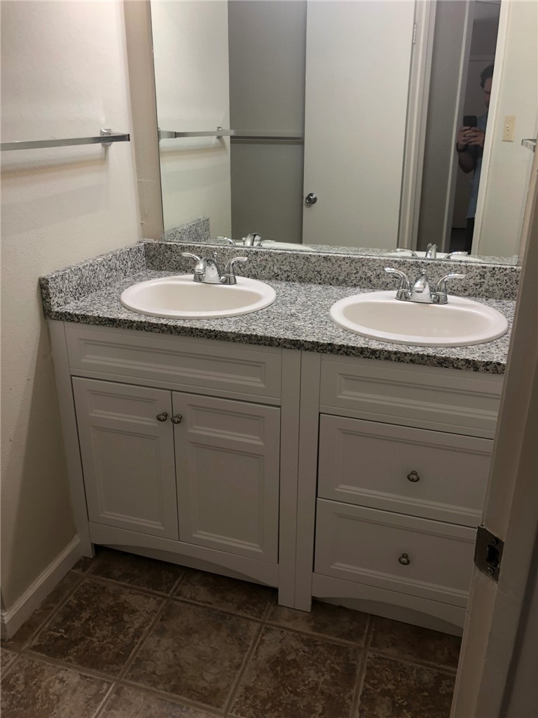 4306 Avenue A, Unit 109 Austin, TX 78751 - Photo 7 of 13 a bathroom with a granite countertop sink and a mirror