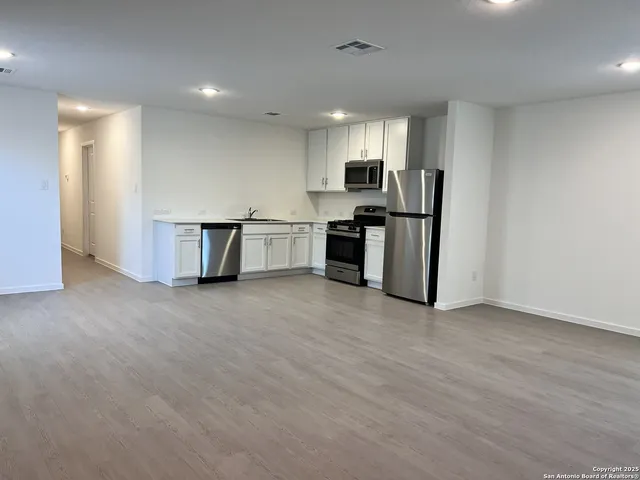 a view of kitchen with refrigerator and microwave
