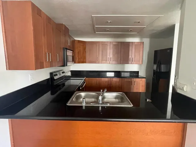 a kitchen with stainless steel appliances granite countertop a refrigerator and a stove