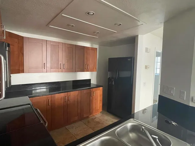 a kitchen with sink a microwave and cabinets