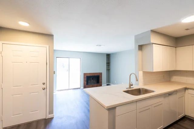 a kitchen with a sink a refrigerator and cabinets