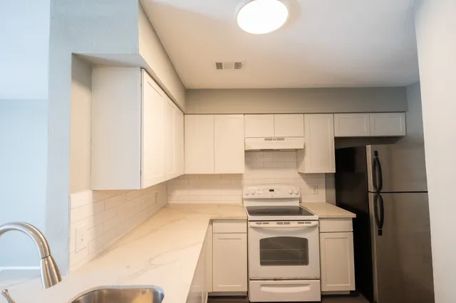 a kitchen with a white stove top oven and sink