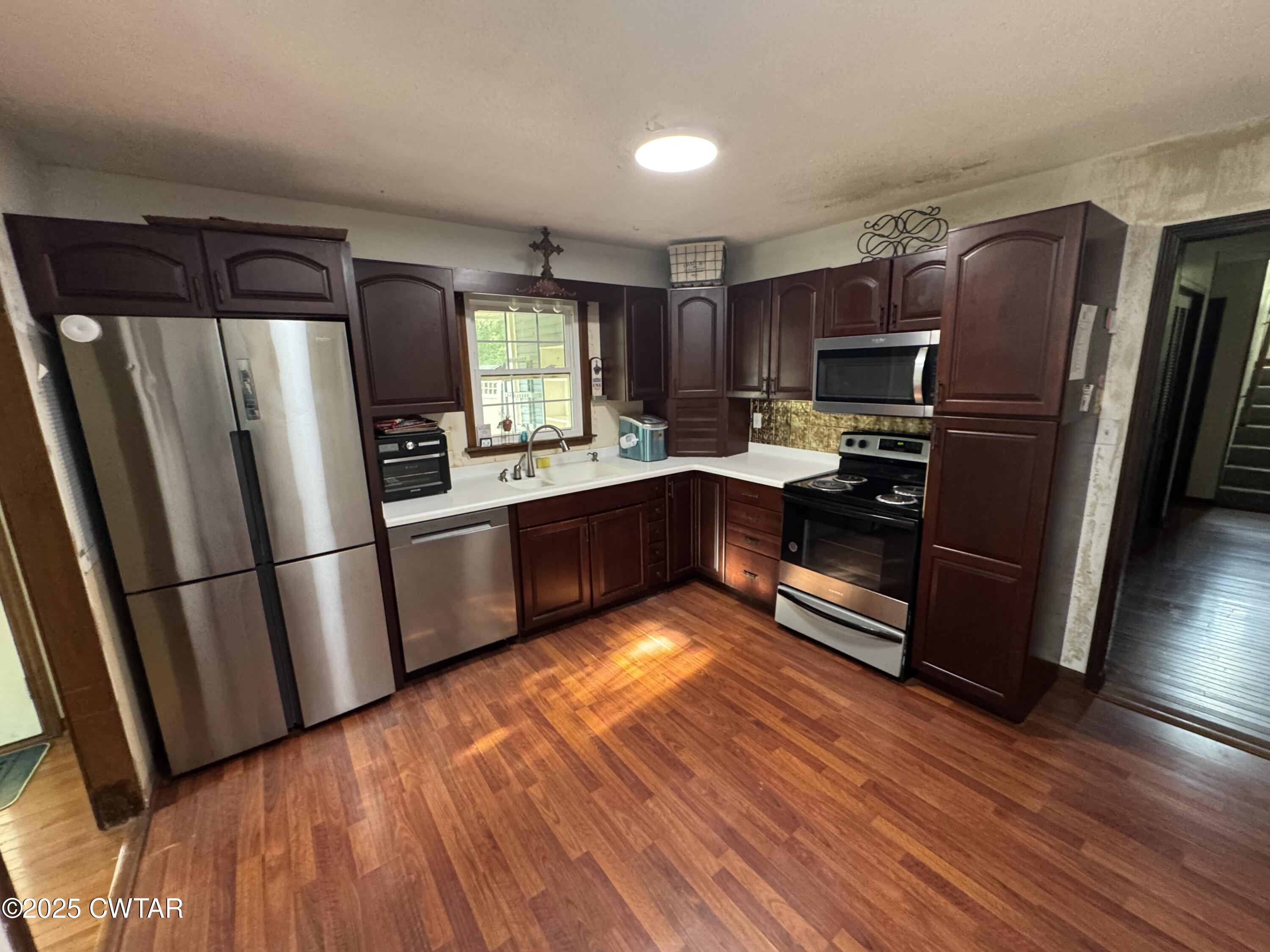 274 Fox Ridge Road Jackson, TN 38305 - Photo 4 of 16 a kitchen with stainless steel appliances a refrigerator a sink wooden floor and cabinets