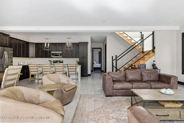 a living room with furniture and a view of kitchen