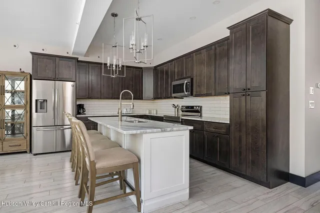 a kitchen with granite countertop wooden cabinets stainless steel appliances and a counter top space