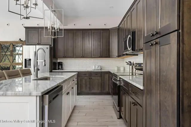 a kitchen with stainless steel appliances granite countertop a sink and a stove