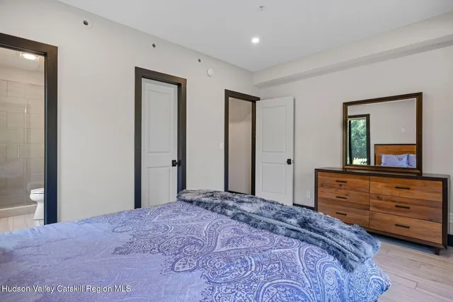 a bedroom with a bed lamp and a large window