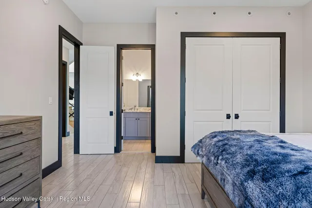 a bedroom with a bed and a large mirror next to a window