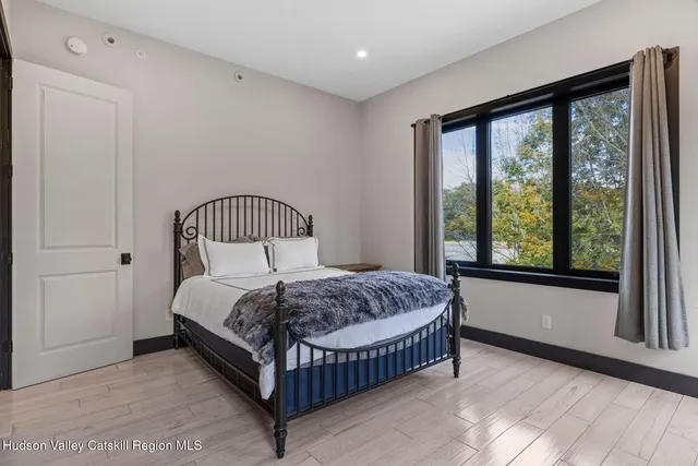 a bedroom with a bed and large window