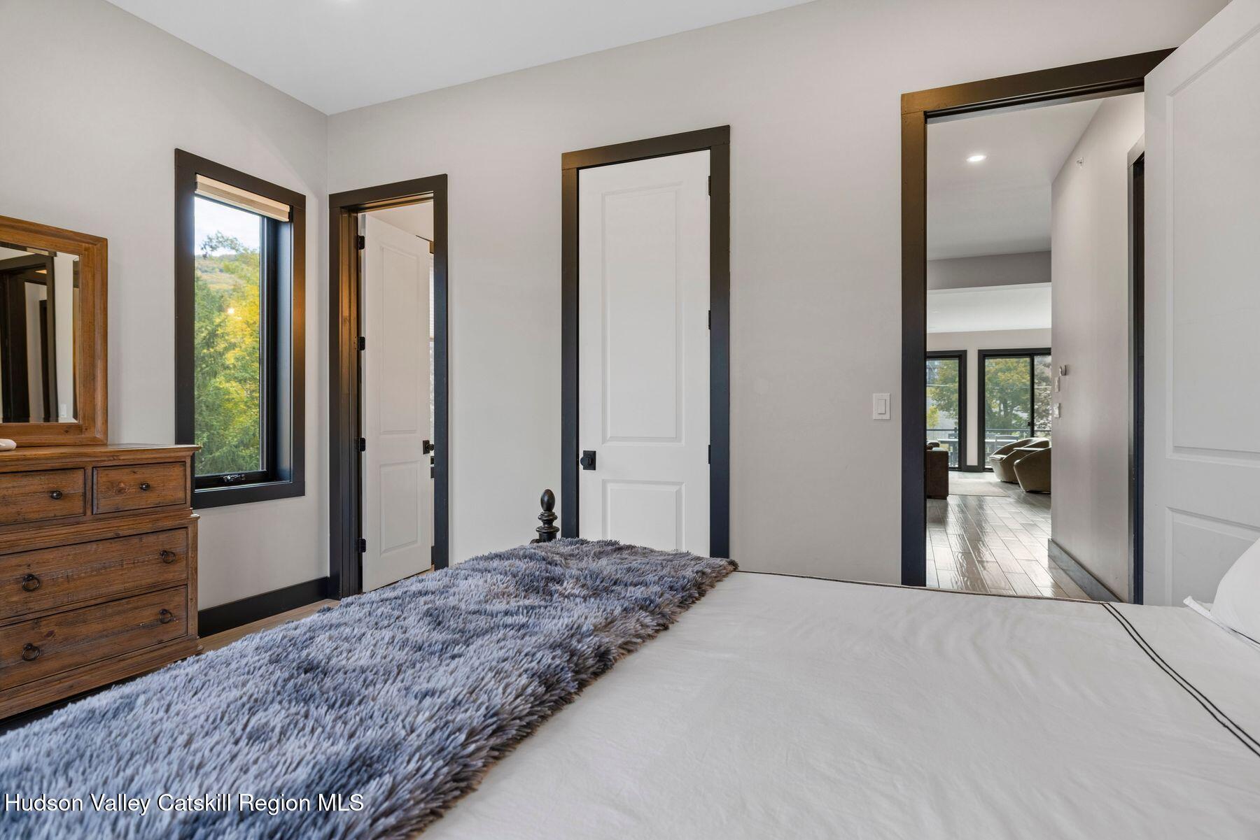 3 South Street Windham, NY 12496 - Photo 30 of 61 a bedroom with a bed and a large mirror next to a window