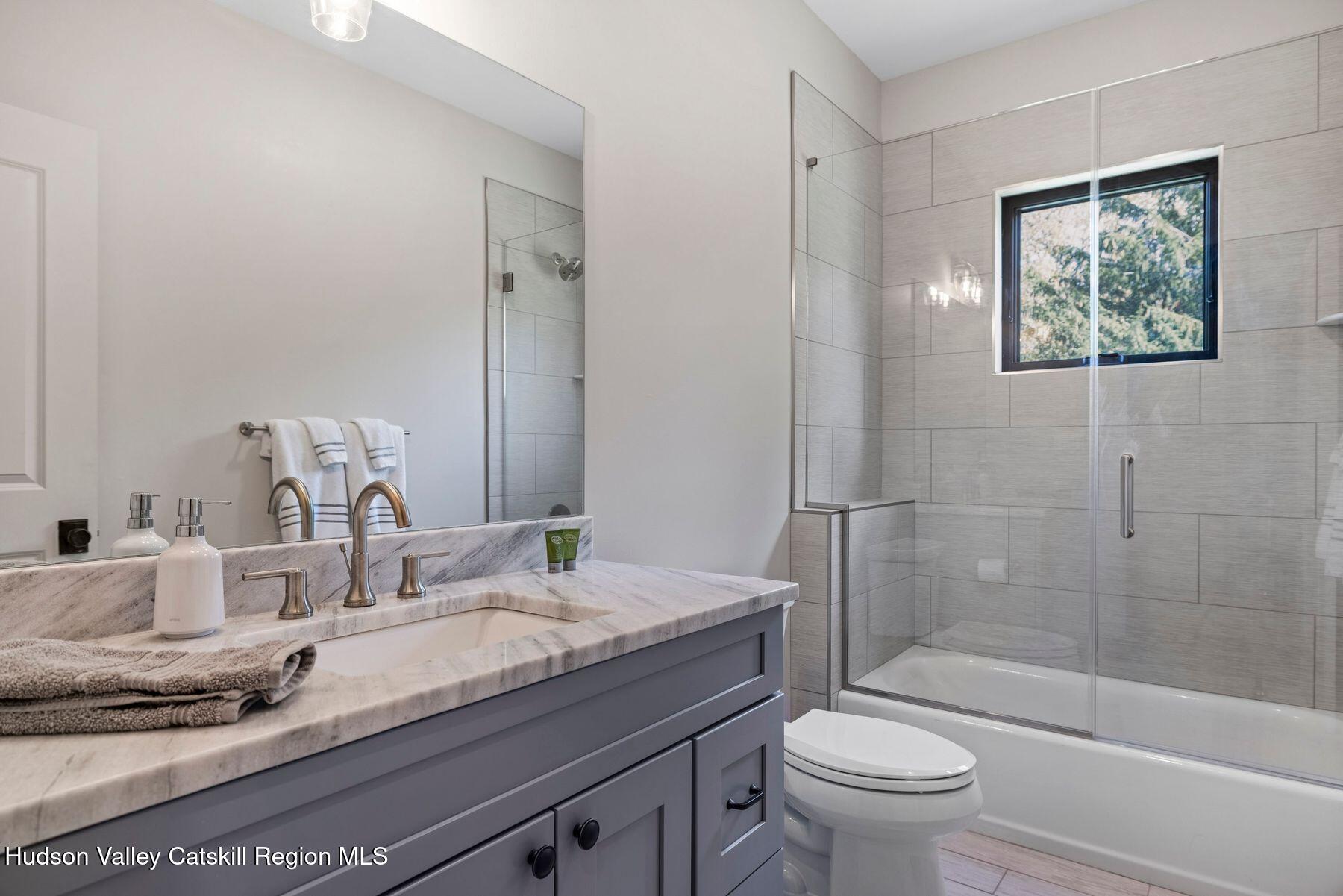 3 South Street Windham, NY 12496 - Photo 42 of 61 a bathroom with a granite countertop sink a toilet and shower
