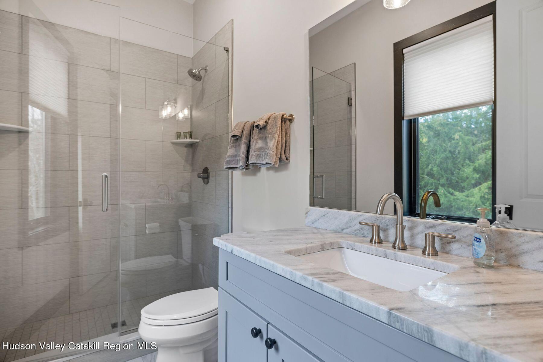 3 South Street Windham, NY 12496 - Photo 43 of 61 a bathroom with a granite countertop sink a toilet and shower