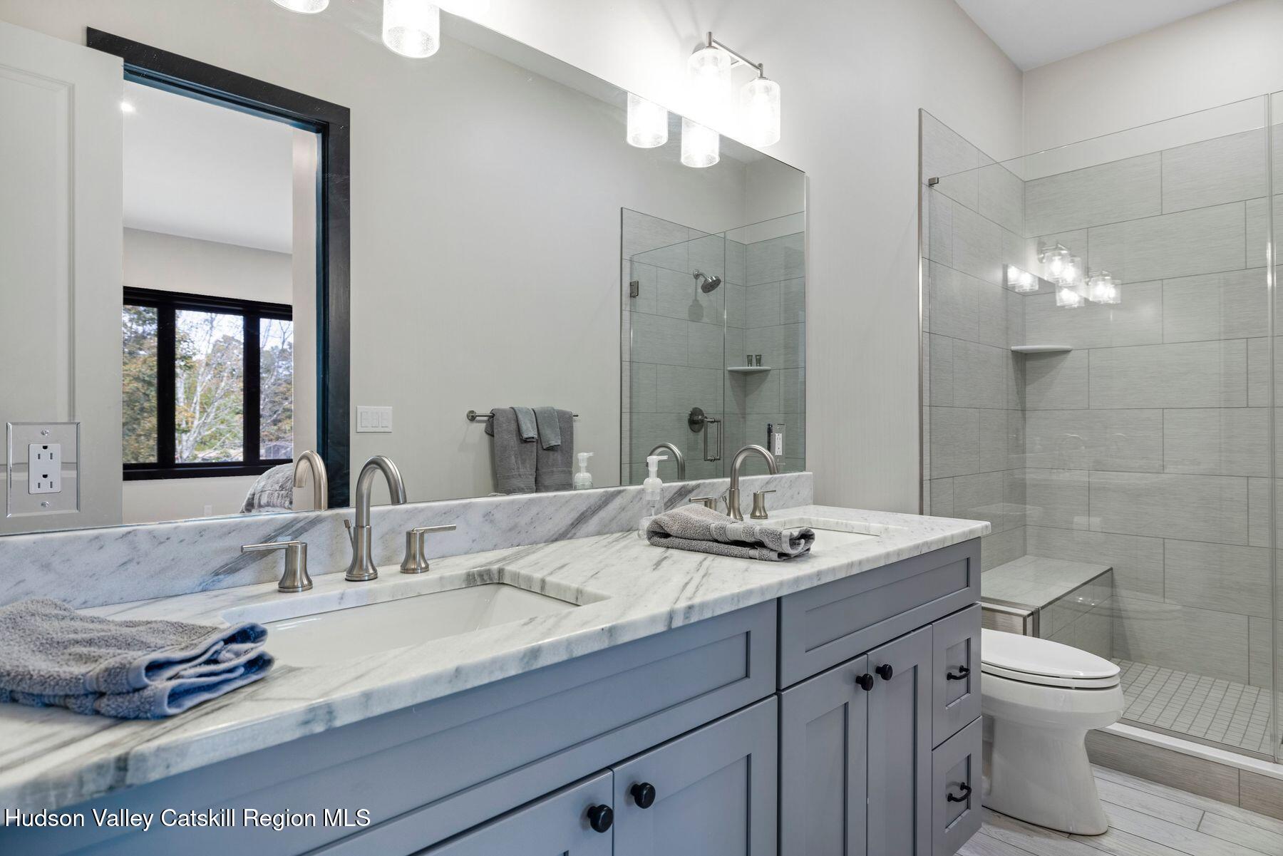 3 South Street Windham, NY 12496 - Photo 44 of 61 a bathroom with a granite countertop sink a toilet and a mirror