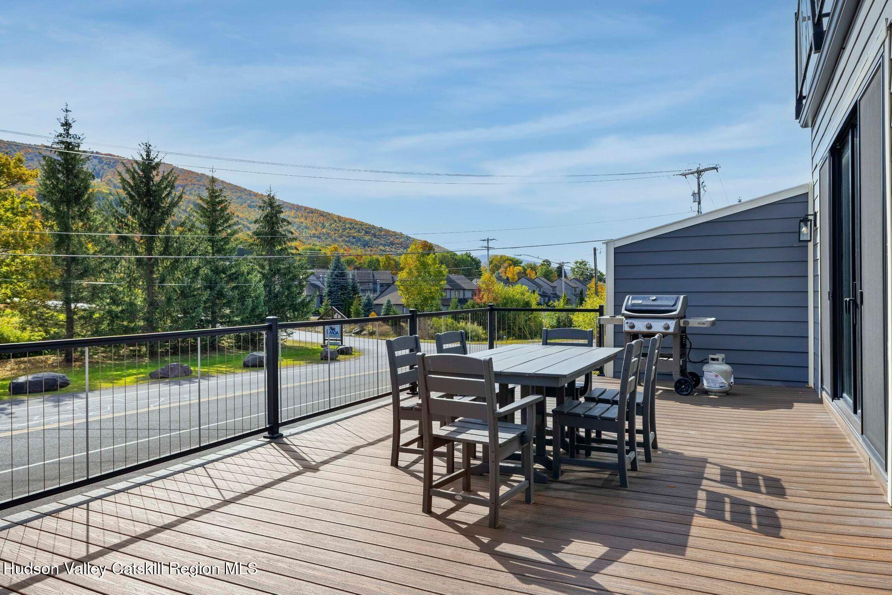3 South Street Windham, NY 12496 - Photo 57 of 61 a view of a roof deck with table and chairs a barbeque with wooden floor and fence