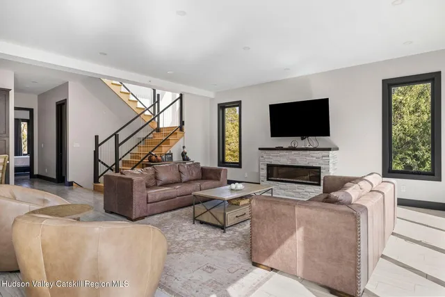 a living room with furniture a flat screen tv and a fireplace