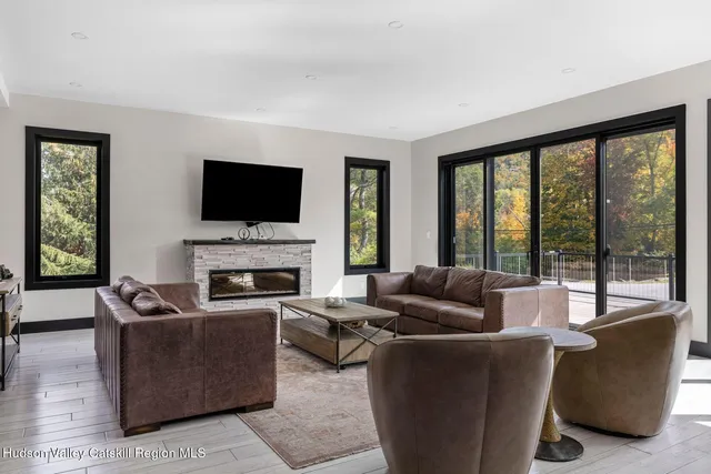 a living room with furniture a flat screen tv and a fireplace