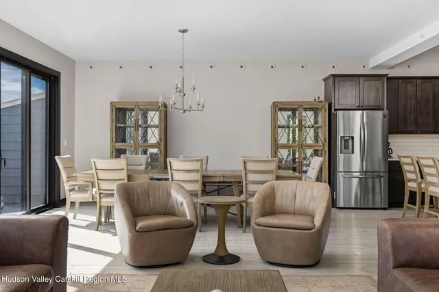 a living room with furniture and a refrigerator