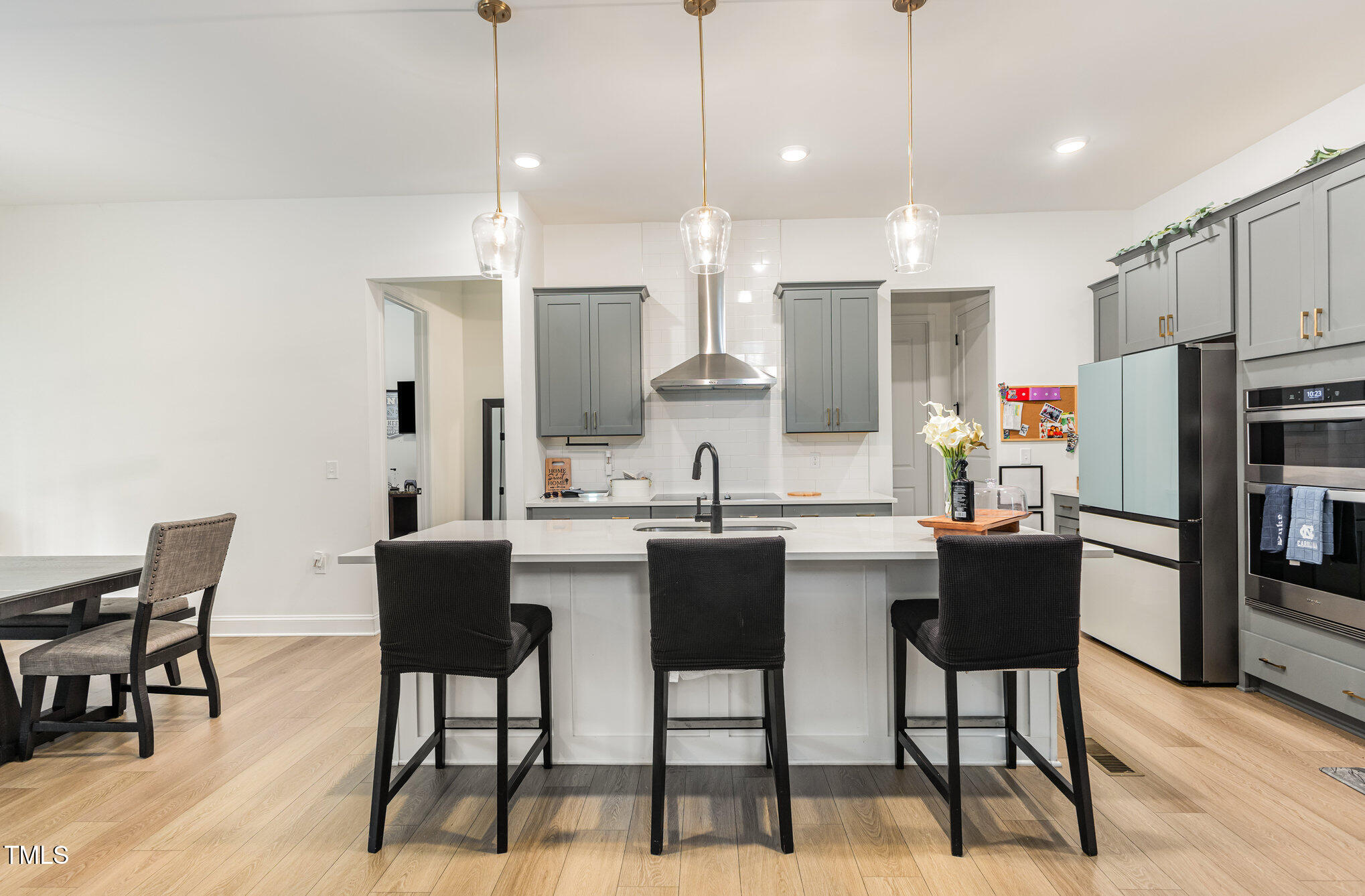 25 Cackling Way Zebulon, NC 27597 - Photo 13 of 32 a kitchen with stainless steel appliances kitchen island granite countertop a dining table chairs and a refrigerator