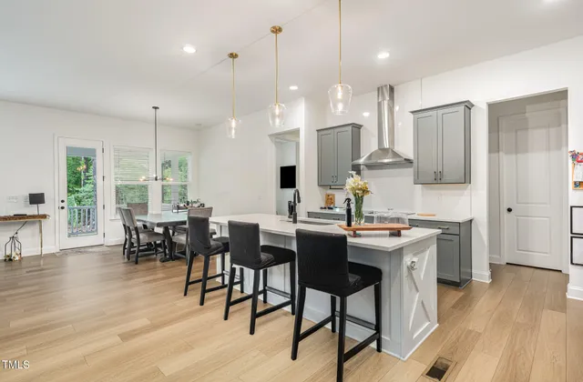 a kitchen with stainless steel appliances granite countertop sink cabinets dining table and chairs