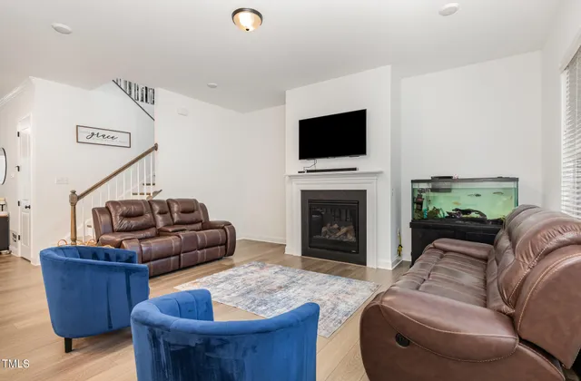a living room with furniture a flat screen tv and a fireplace