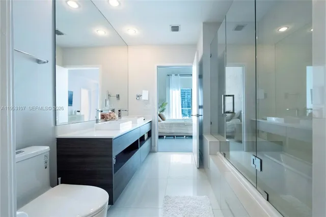 a bathroom with a sink a toilet and shower