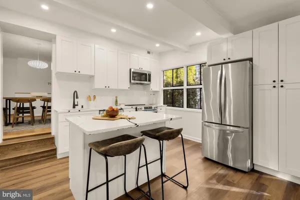 a kitchen with stainless steel appliances granite countertop a refrigerator and a stove top oven