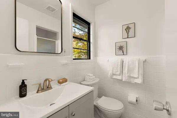 a bathroom with a toilet sink and mirror