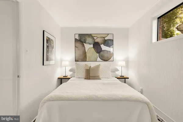 a bedroom with a bed and painting on the wall