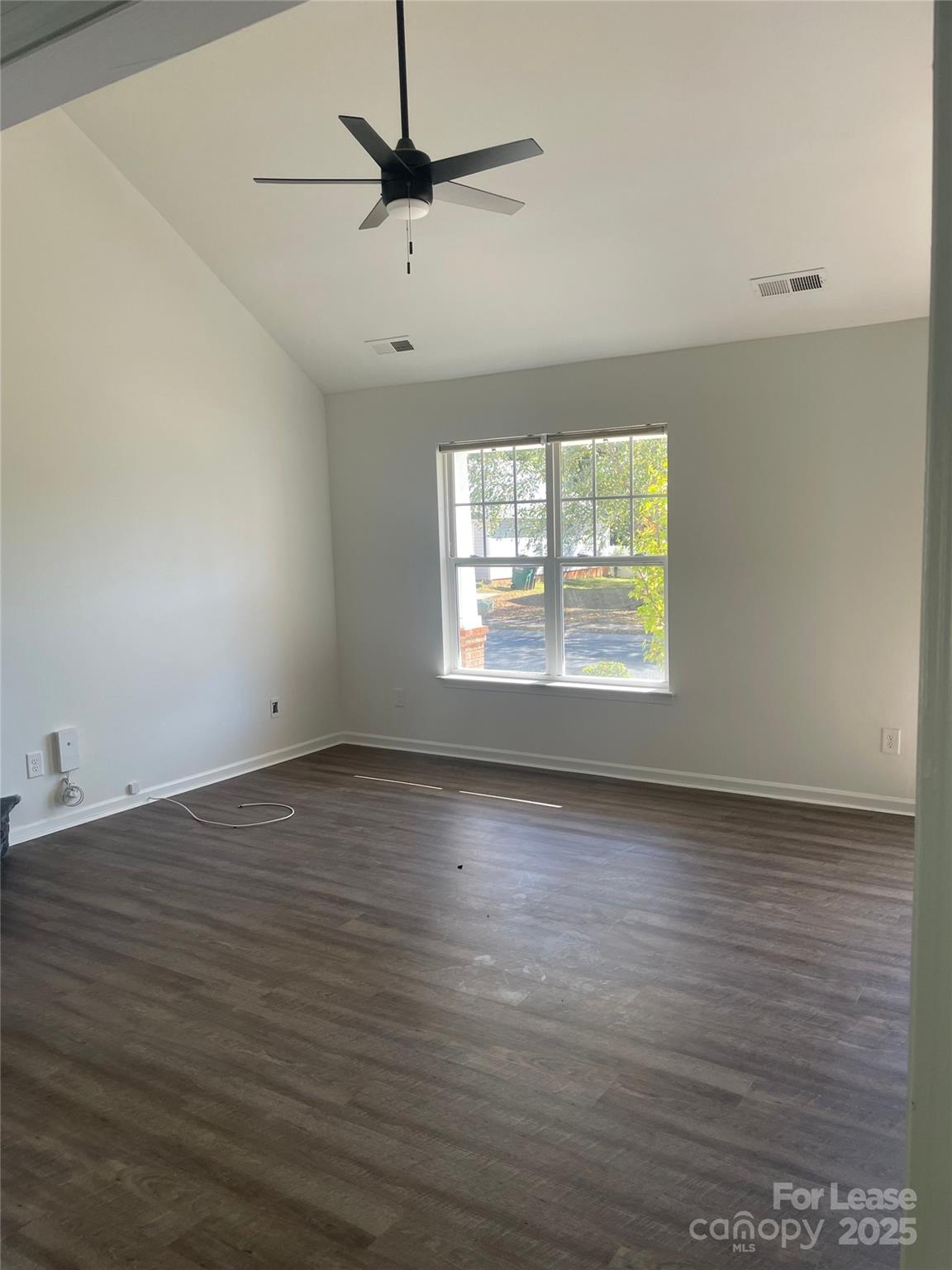 242 Amir Circle Matthews, NC 28105 - Photo 16 of 22 an empty room with wooden floor chandelier and windows