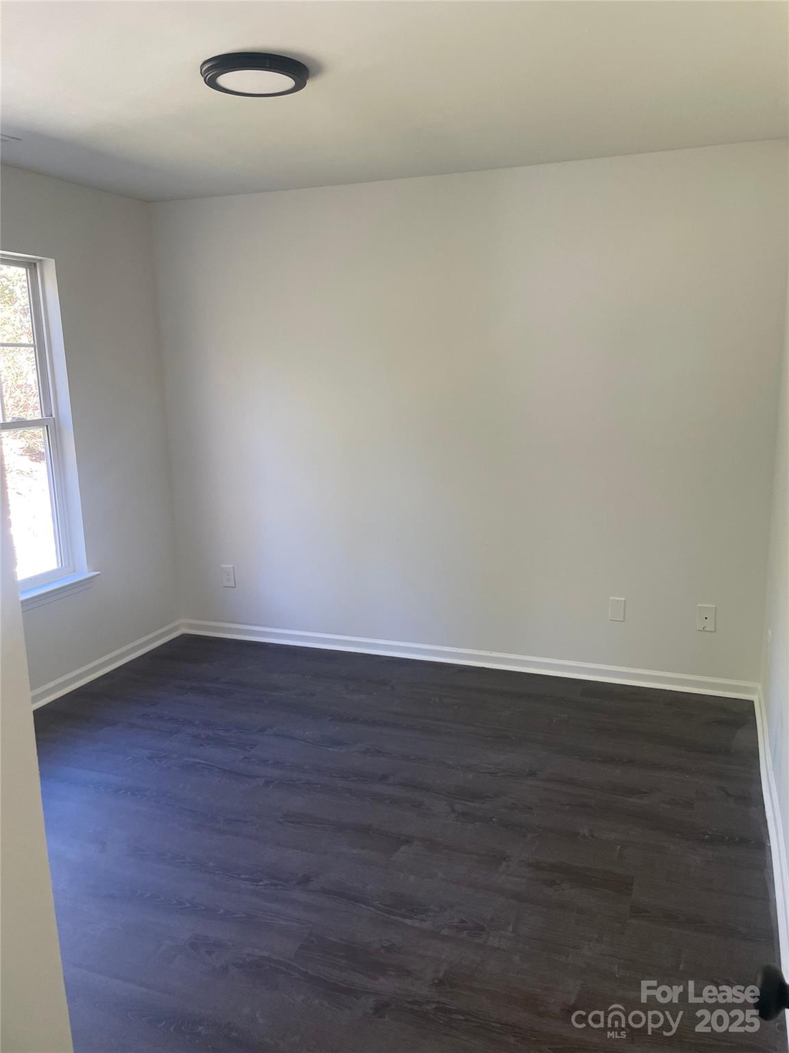 242 Amir Circle Matthews, NC 28105 - Photo 4 of 22 an empty room with wooden floor and windows