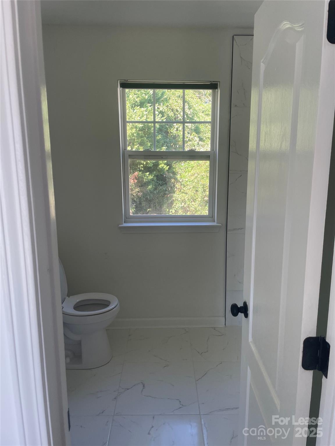 242 Amir Circle Matthews, NC 28105 - Photo 7 of 22 a white toilet sitting in a bathroom next to a window