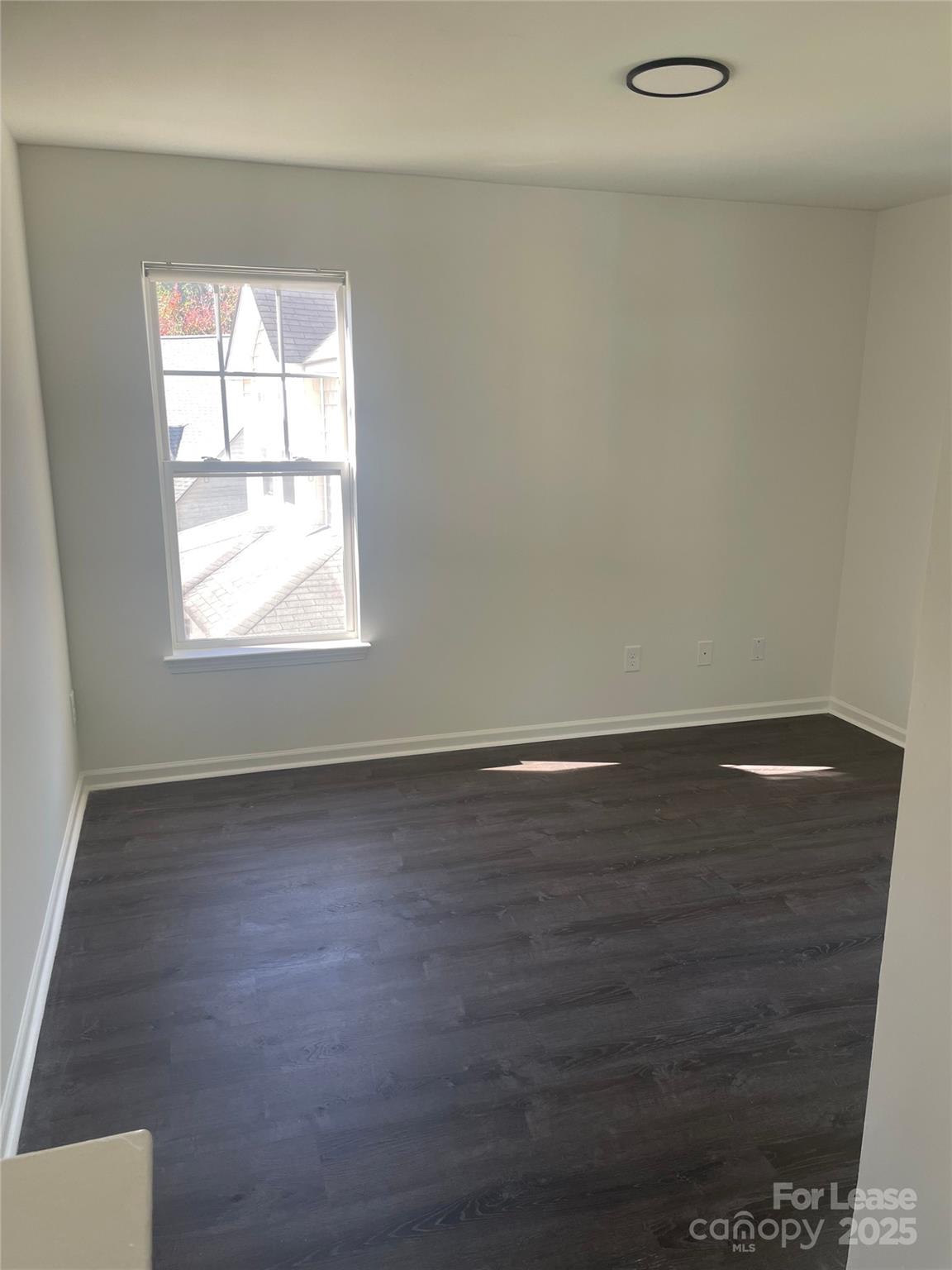 242 Amir Circle Matthews, NC 28105 - Photo 9 of 22 an empty room with wooden floor and windows