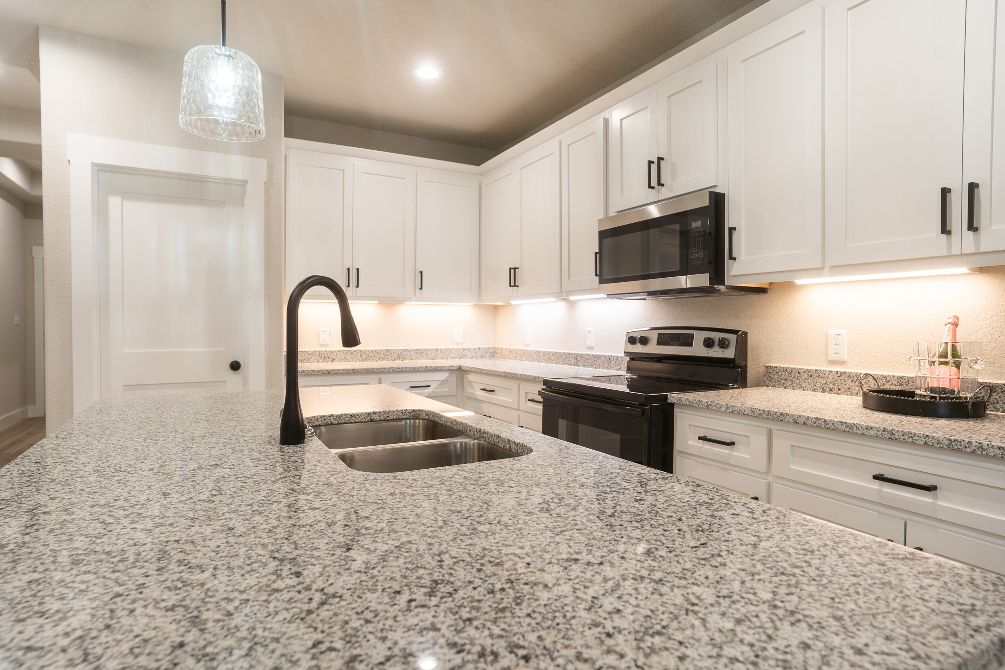 307 String Prairie Way Smithville, TX 78957 - Photo 13 of 34 a kitchen with kitchen island granite countertop a stove sink and microwave