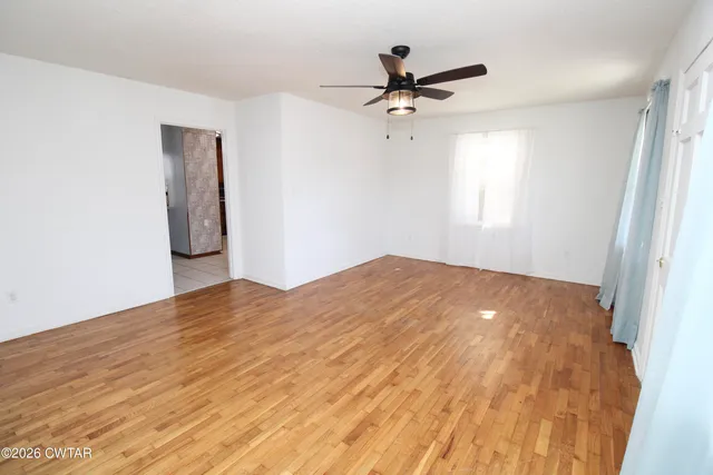a view of a big room with wooden floor and windows in a room