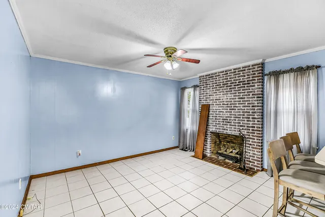 a view of empty room with fireplace and fan