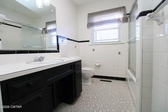 a bathroom with a sink a toilet a mirror and shower