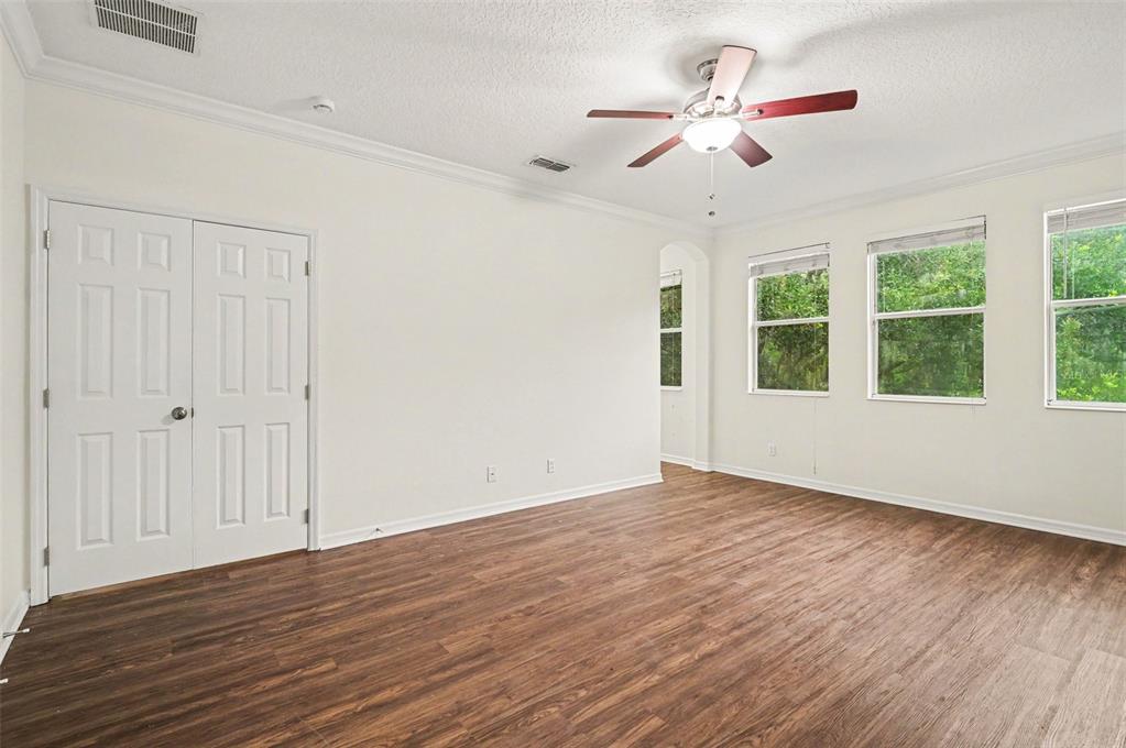 4819 Indian Deer Road Windermere, FL 34786 - Photo 14 of 30 a view of an empty room with wooden floor and a ceiling fan