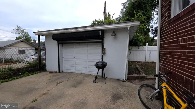 a backyard of a house with barbeque oven and trees